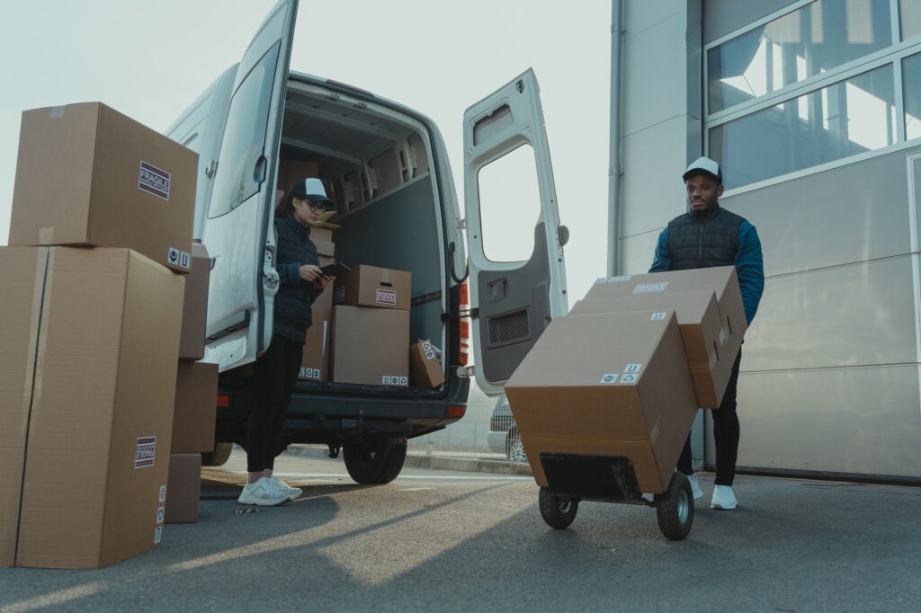 Empleados de Temma Freight entregando cajas de envios internacionales.